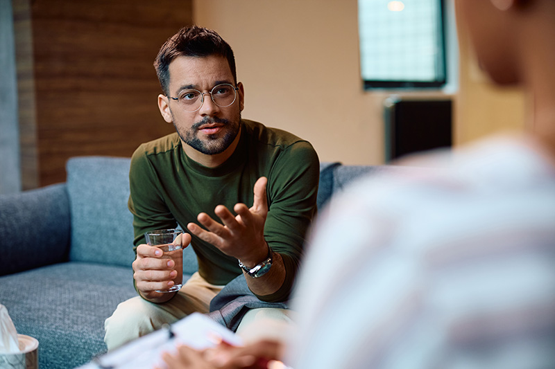 A man participates in a session of cognitive behavioral therapy for addiction treatment.