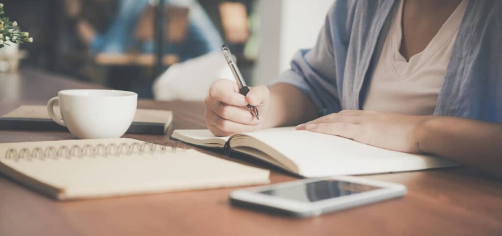 Woman sits at a table with a notebook looking over her list of Benzodiazepines.